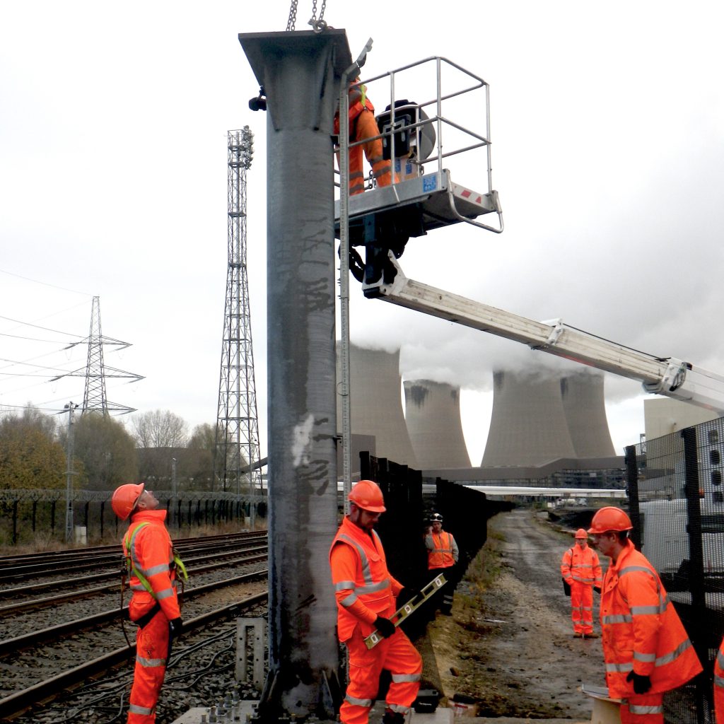 Bridgeway engineers working trackside with power station cooling towers behind