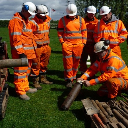A group of Bridgeway engineers in orange PPE during a hands-on training session